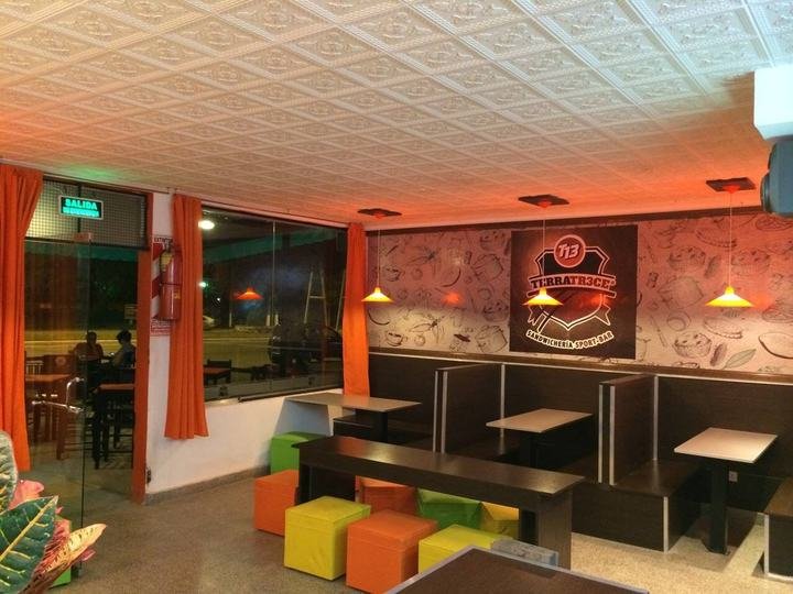 Salón de sandwichería con boxes y banquetas de colores