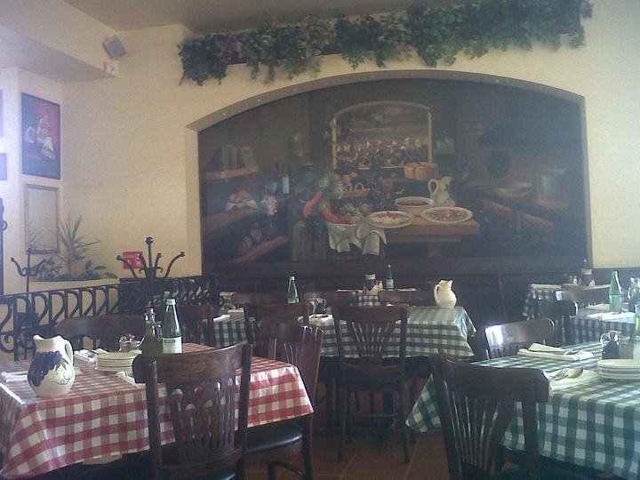 Salón de trattoria con mesas preparadas
