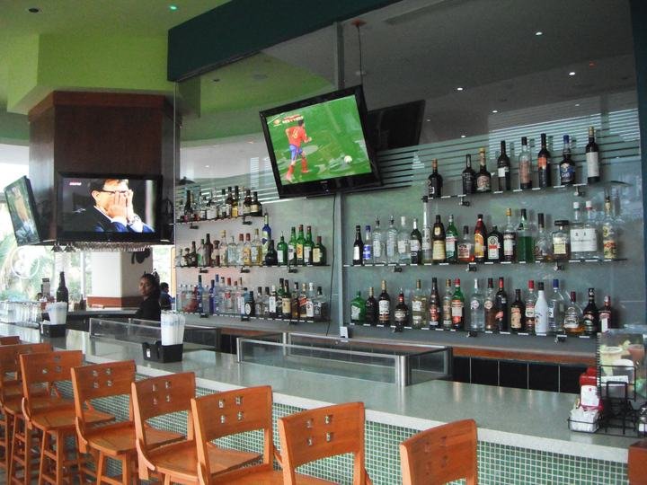 Barra de bar preparada con banquetas y botellas ordenadas
